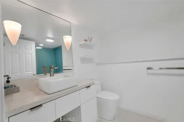 a bathroom with a sink vanity granite and toilet