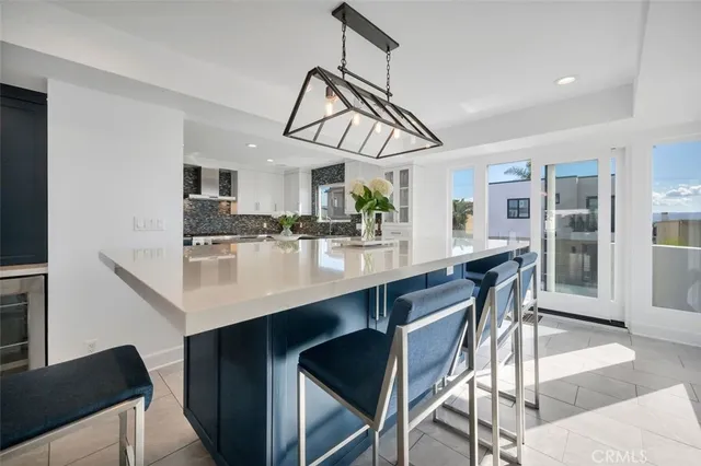 a kitchen with a dining table chairs stainless steel appliances and cabinets
