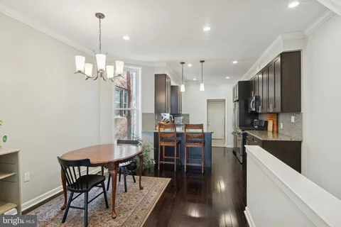 a view of a dining room and livingroom with furniture wooden floor a chandelier