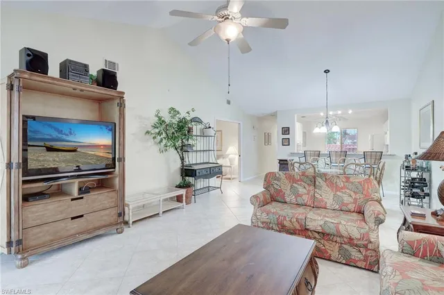a living room with furniture a fireplace and a chandelier