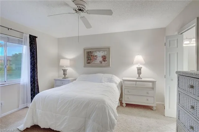 a spacious bedroom with a bed a lamp and chandelier