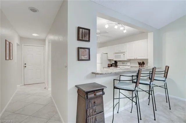a kitchen with stainless steel appliances kitchen island granite countertop a refrigerator and cabinets