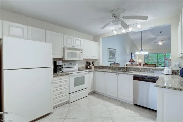 a kitchen with granite countertop cabinets appliances and a sink