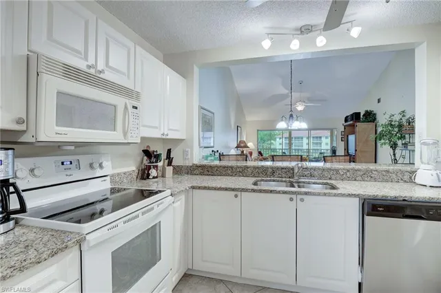 a kitchen with stainless steel appliances granite countertop a sink and cabinets