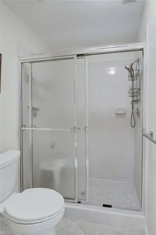 a white toilet next to a bathroom