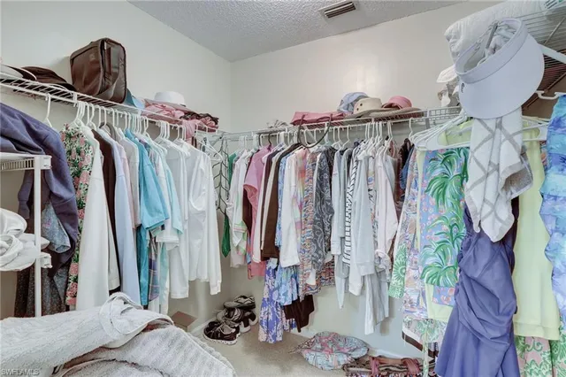a view of walk in closet with clothes and shoes