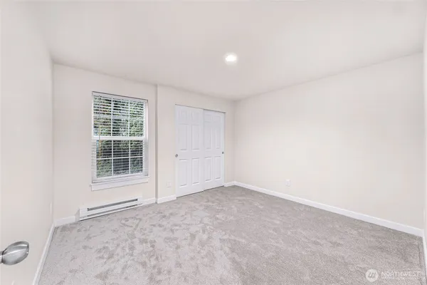 a bedroom with a large bed and a window