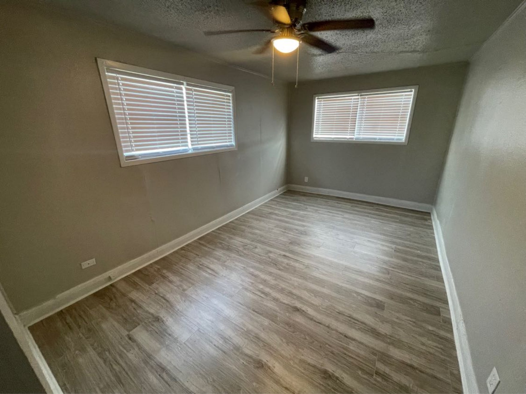 1649 19th Street Port Arthur, TX 77640 - Photo 3 of 8 a view of an empty room with wooden floor and a window