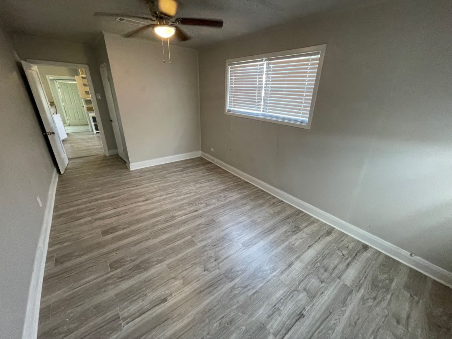 1649 19th Street Port Arthur, TX 77640 - Photo 6 of 8 a view of an empty room with wooden floor and a window