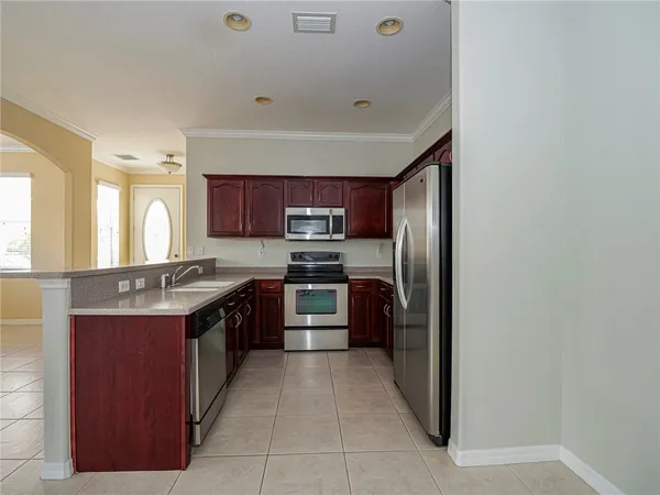 a large kitchen with stainless steel appliances granite countertop a stove top oven a sink and dishwasher