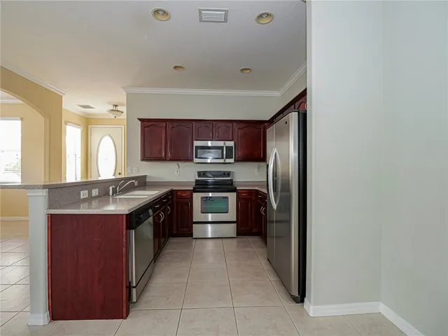 a large kitchen with stainless steel appliances granite countertop a stove top oven a sink and dishwasher