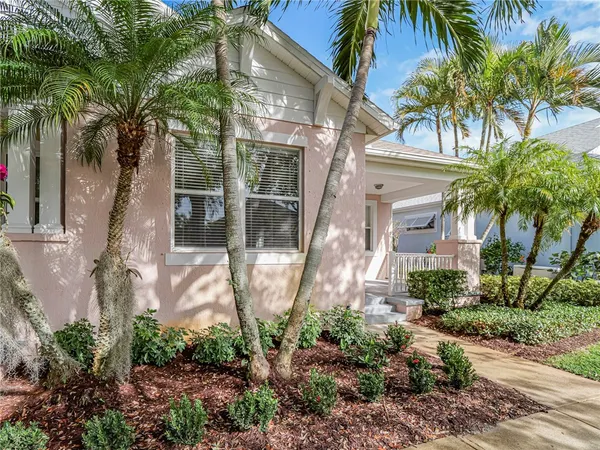 a front view of a house with a yard and potted plants