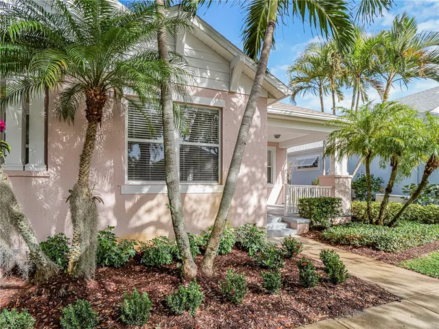 a front view of a house with a yard and potted plants