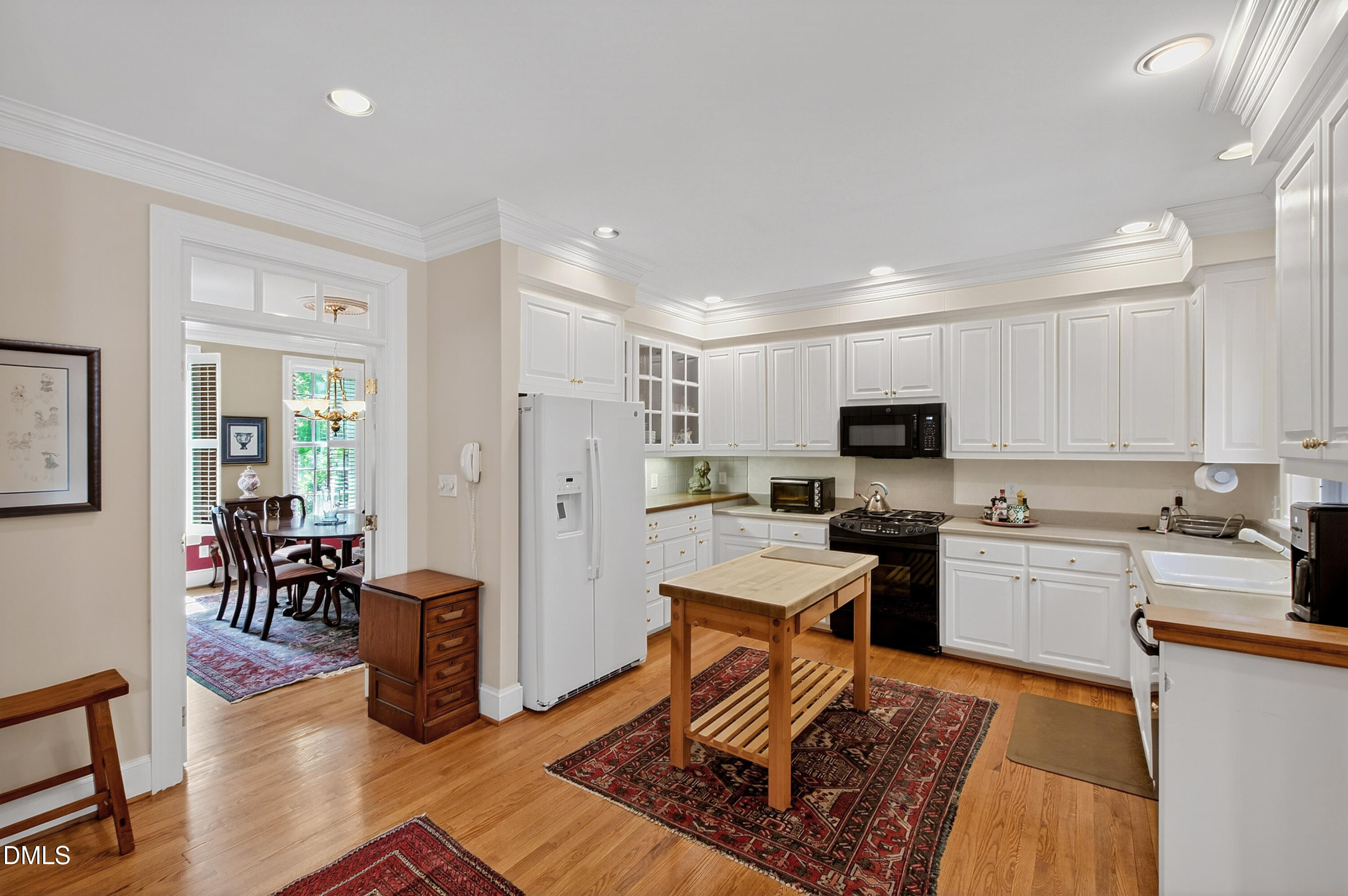 3708 Lubbock Drive Raleigh, NC 27612 - Photo 11 of 64 a open kitchen with stainless steel appliances granite countertop a stove top oven a sink dishwasher a dining table and chairs with wooden floor