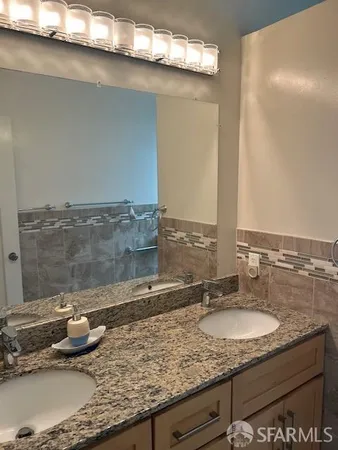 a bathroom with a granite countertop sink and a mirror