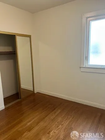 an empty room with wooden floor and a window