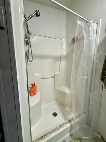 a bathroom with a sink mirror and shower