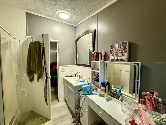 a room with wooden floor stainless steel appliances and cabinets