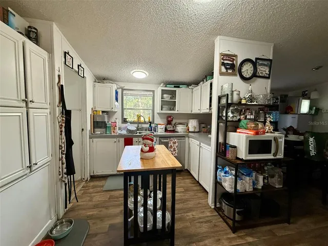 a living room with lots of furniture and kitchen view