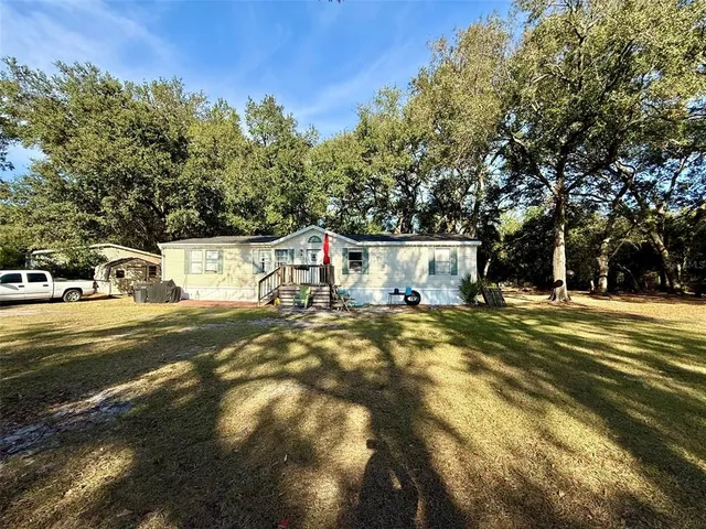 a view of a house with pool and trees around