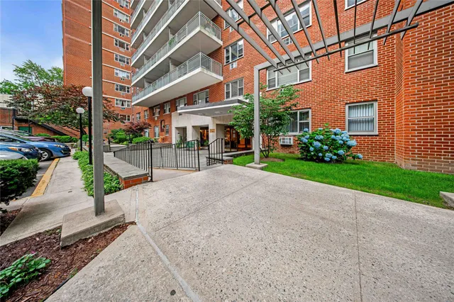 a view of a brick building with a yard and plants