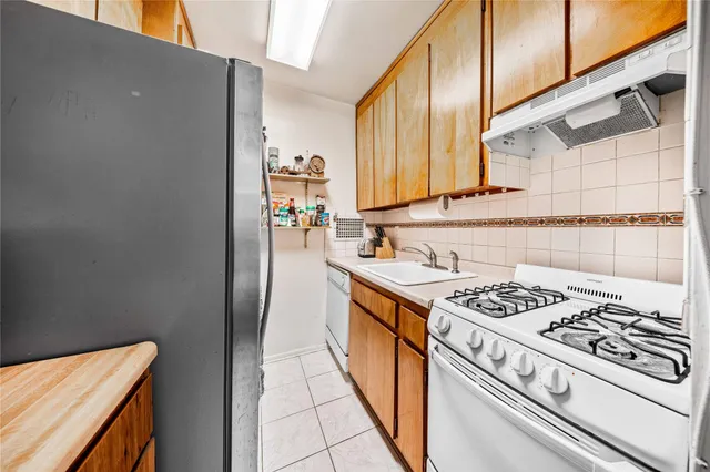 a kitchen with stainless steel appliances a stove a sink and a refrigerator