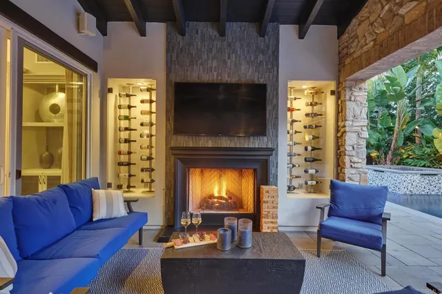 a living room with furniture a fireplace and a large window