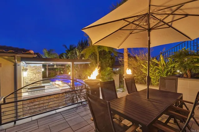 a view of a patio with table and chairs under an umbrella