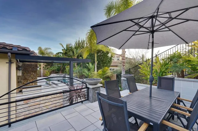 a view of a patio with table and chairs under an umbrella