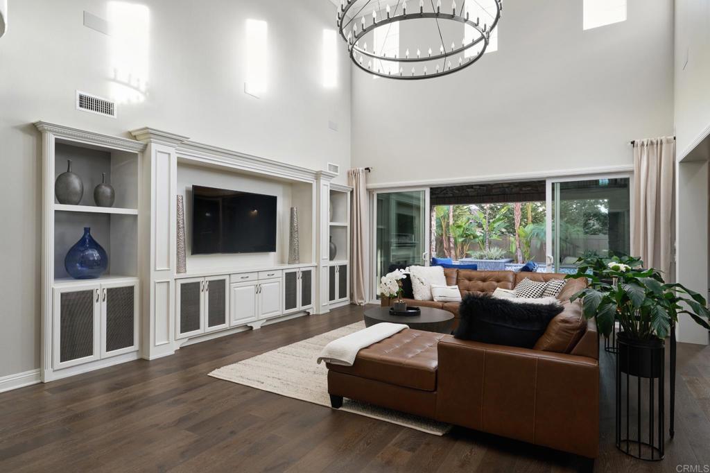 3615 Corte Claro Carlsbad, CA 92009 - Photo 30 of 49 a living room with furniture a flat screen tv and a floor to ceiling window