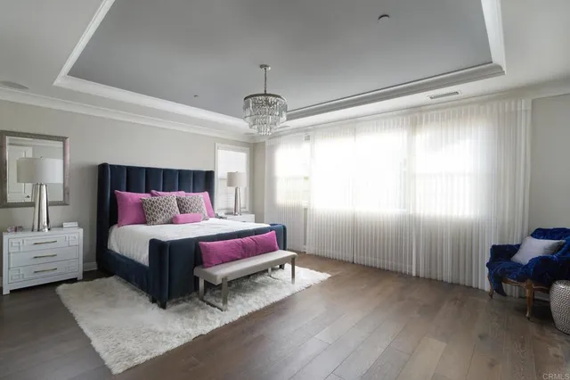 a bedroom with a bed and a chandelier