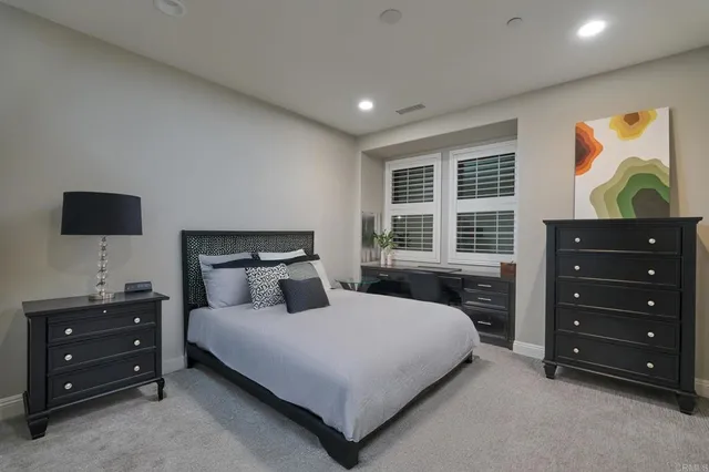 a bedroom with a bed and a flat tv screen on dresser