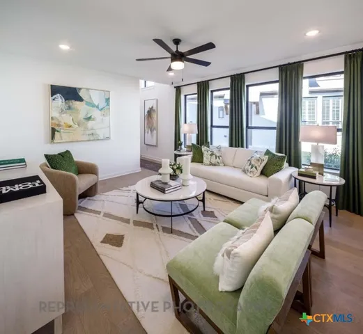 a living room with furniture and a large window with wooden floor
