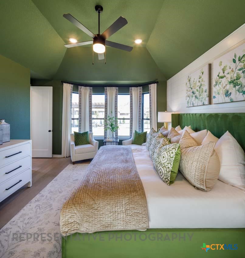133 Three Oaks Lane Georgetown, TX 78628 - Photo 17 of 40 a spacious bedroom with a bed mirror and a large window