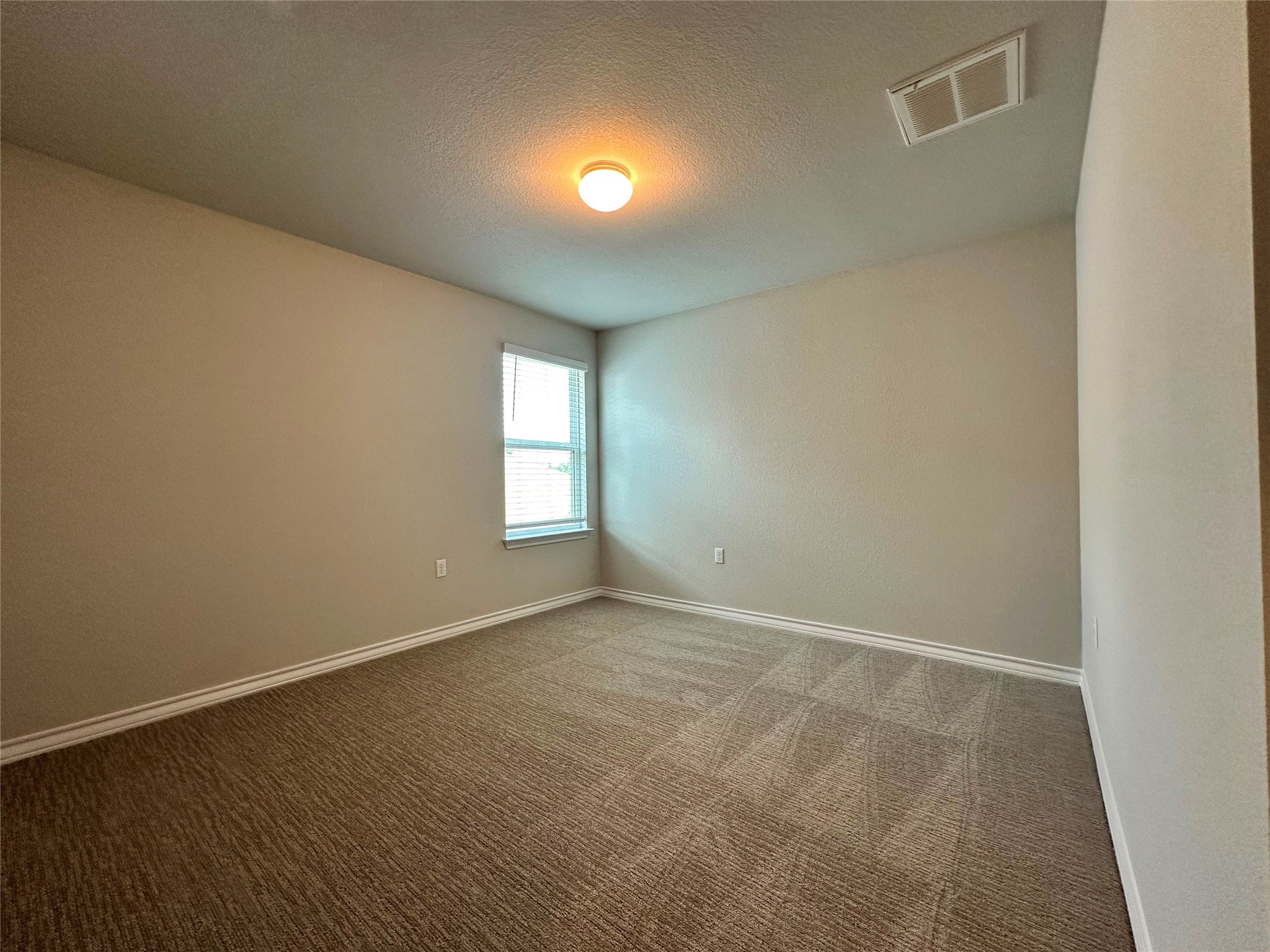 1624 Caballo Blanco Road Austin, TX 78725 - Photo 12 of 23 An inviting room awaits your personal touch, featuring soft carpet and a window for natural light.
