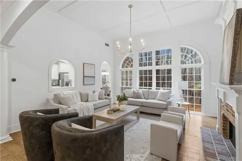 a living room with furniture a fireplace and a floor to ceiling window
