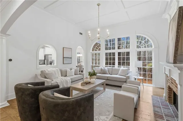 a living room with furniture a fireplace and a floor to ceiling window