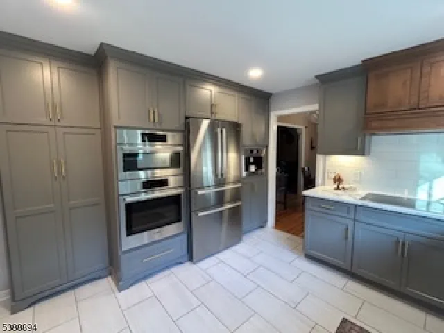a kitchen with stainless steel appliances granite countertop a refrigerator and a sink