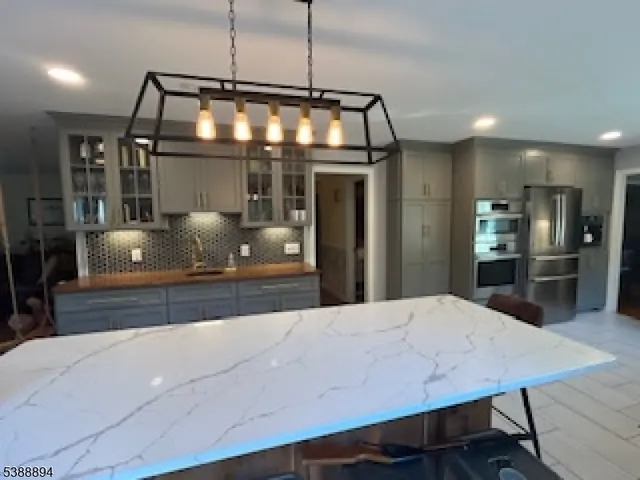 a large kitchen with stainless steel appliances a large counter top