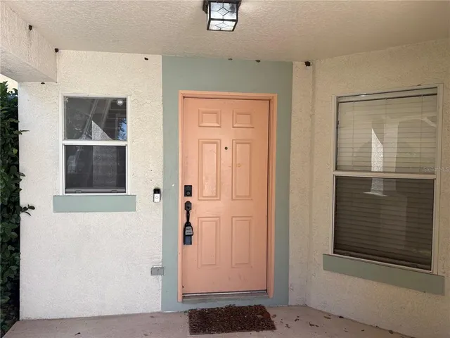 an empty room with wooden floor and windows with curtains