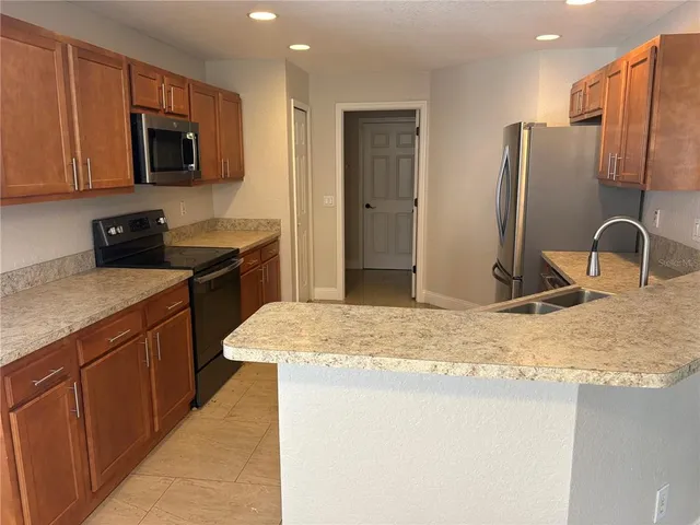 a kitchen with stainless steel appliances granite countertop a stove a refrigerator and a microwave