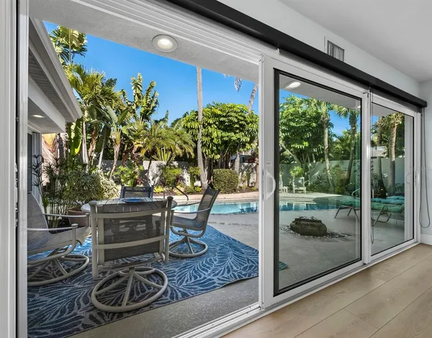 a living room view with a floor to ceiling window and potted plants
