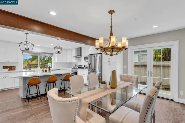 a dining room with furniture a chandelier and wooden floor