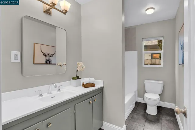 a spacious bathroom with a toilet sink and mirror