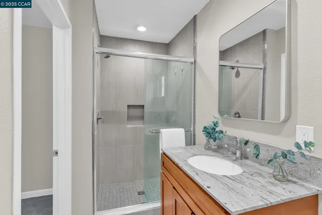 a bathroom with a granite countertop sink shower mirror and a bathtub