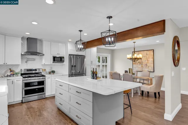 a kitchen with stainless steel appliances kitchen island granite countertop a sink and cabinets