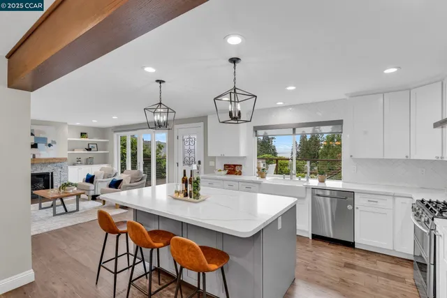 a kitchen with a dining table chairs stainless steel appliances and cabinets