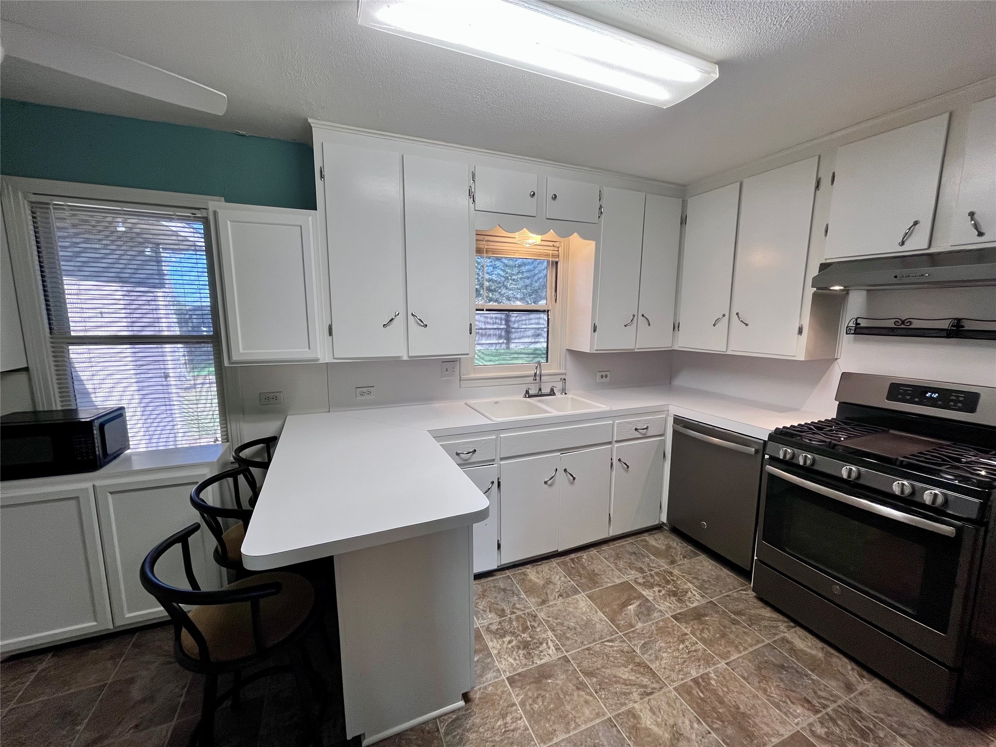 1004 North Center Street Weimar, TX 78962 - Photo 4 of 15 a kitchen with a stove a sink and a microwave