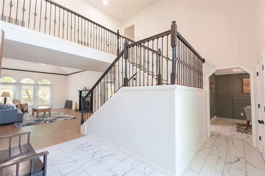 2020 Arbor Bend Road Bonham, TX 75418 - Photo 7 of 40 Complete New Staircase with arched walkways, a high ceiling, and marble look tile flooring