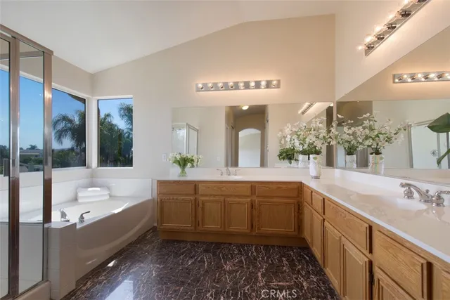 a bathroom with a double vanity sink mirror and bathtub